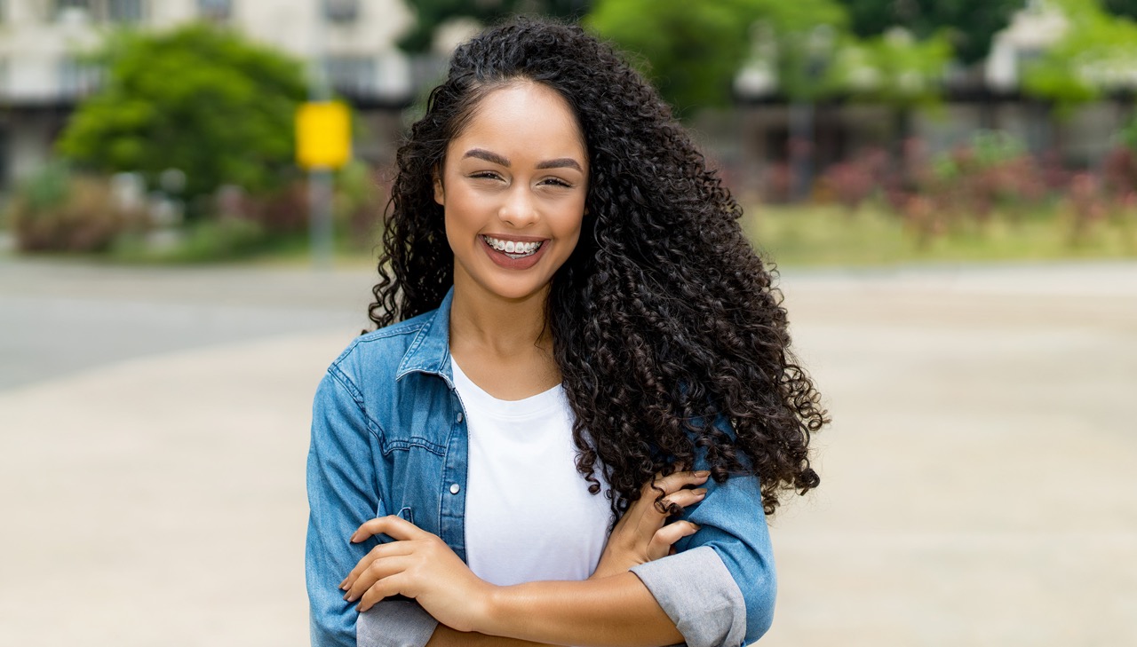 Confident woman smiling with braces, showcasing her transformation with an orthodontist in Mansfield, TX