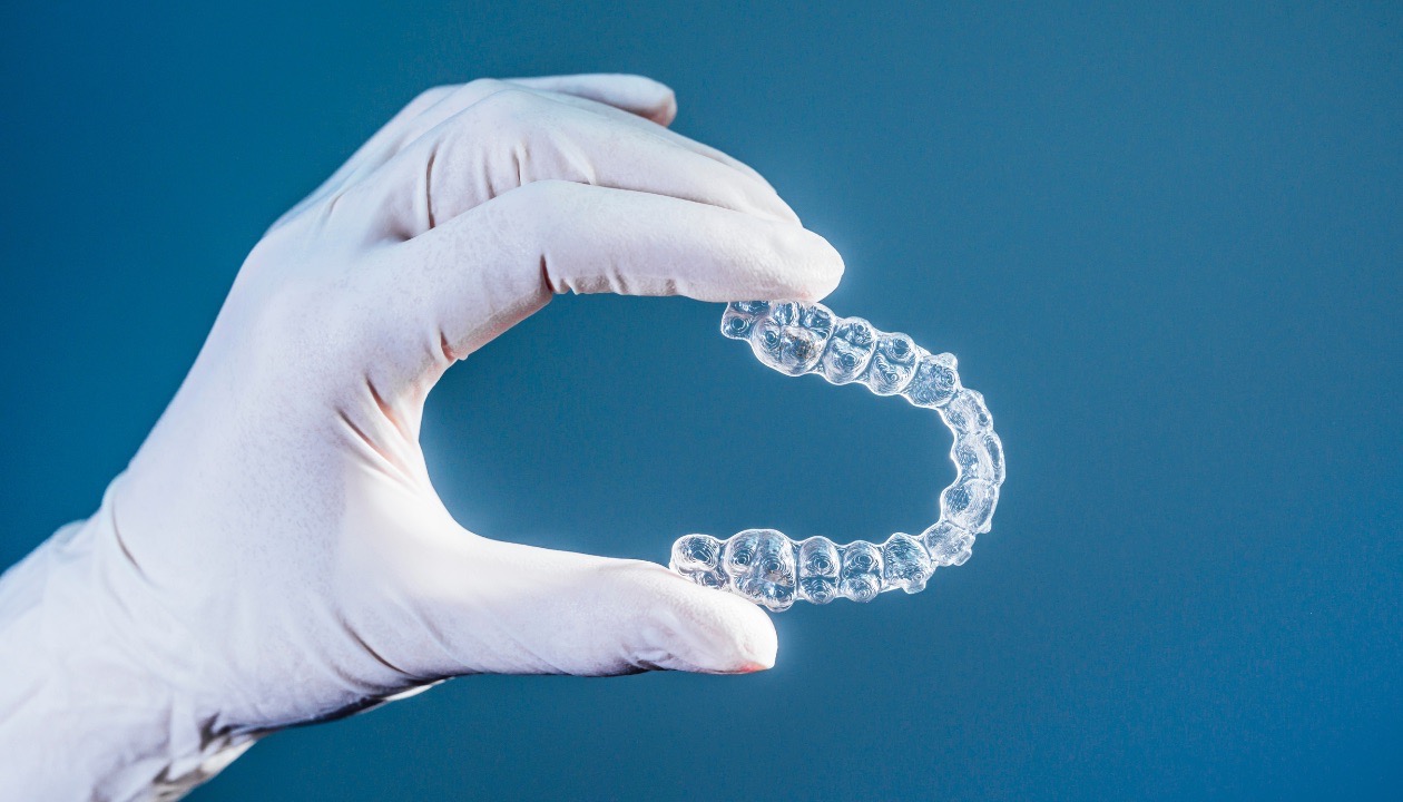 Clear Invisalign aligner held by orthodontist in Mansfield, TX